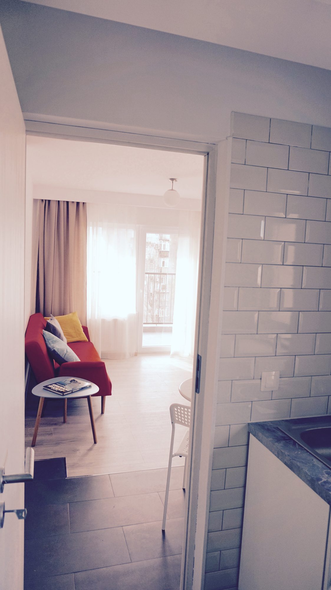 Bucătăria cu faianță albă, privind spre living