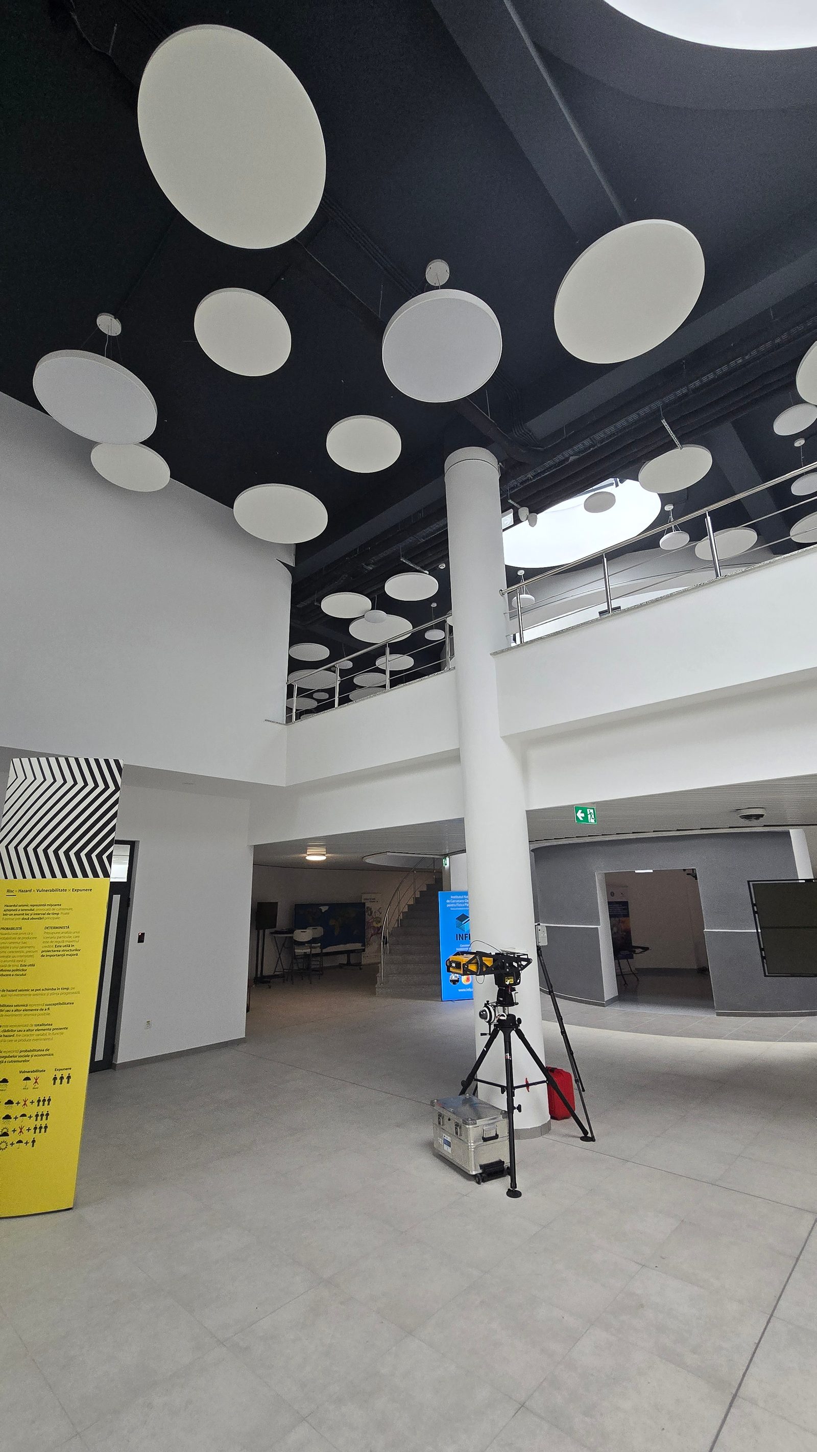 Holul principal văzut din interior, cu stâlpul rotund, galeria de mezanin și câmpul de discuri acustice de pe tavan