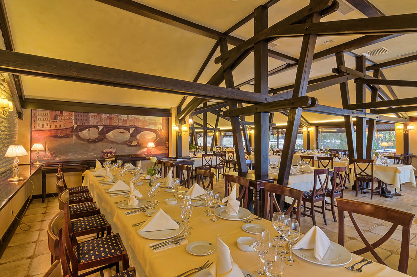 Restaurantul rustic, cu șarpanta aparentă și mesele așezate